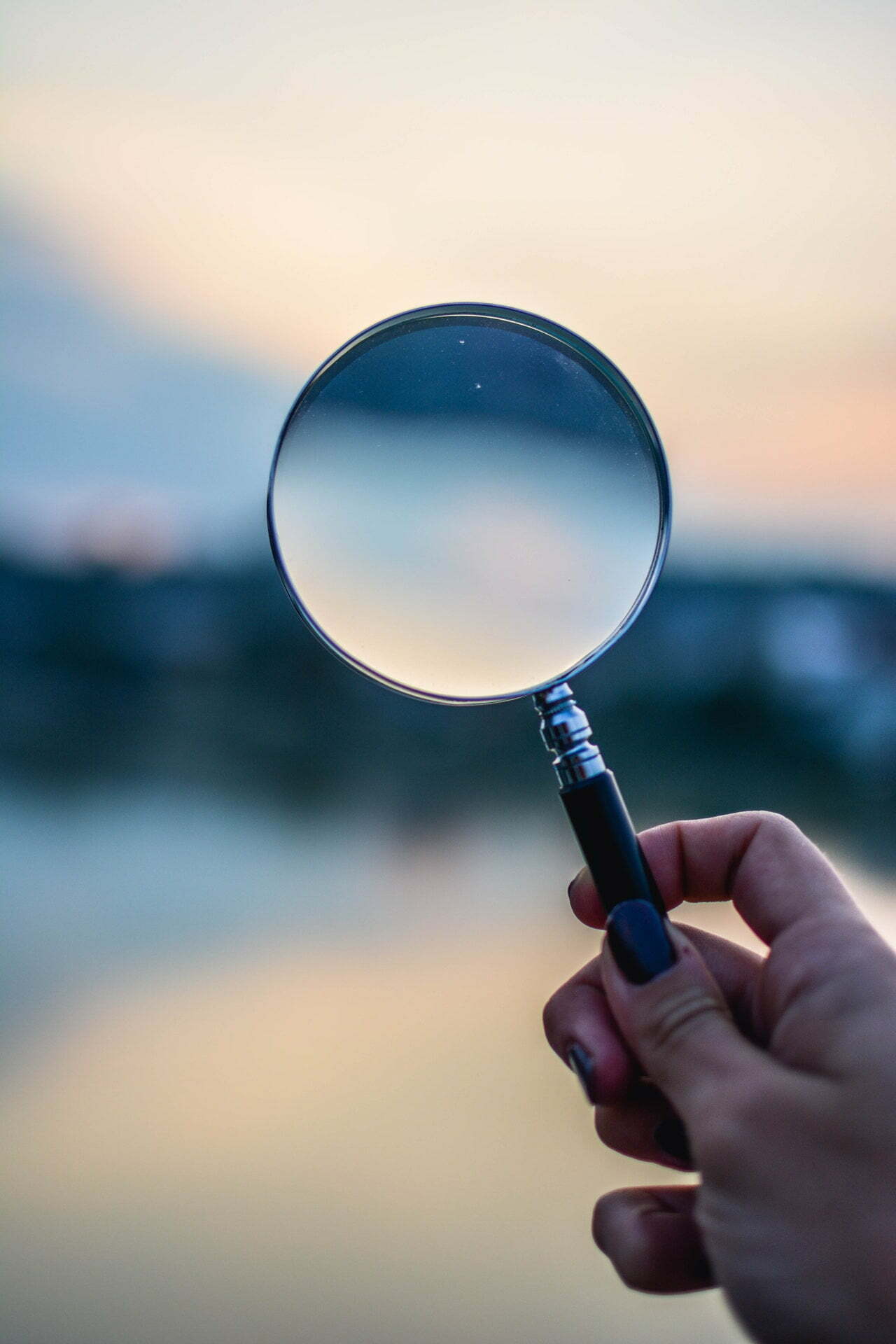 a hand holding a magnifying glass
